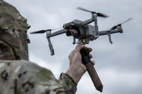 A soldier launching a small quadcopter by hand.